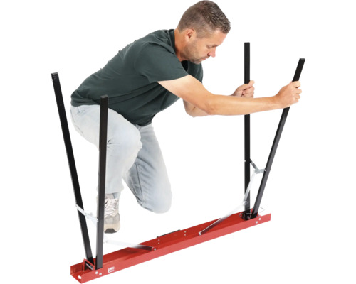 Un homme utilise un dispositif de transport pour plaques de plâtre.