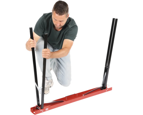 Un homme assemble un outil d'aide au montage pour vitres automobiles.