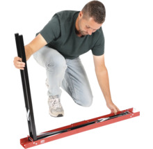 Un homme assemble un gabarit de coupe de carreaux en métal pour grands carreaux