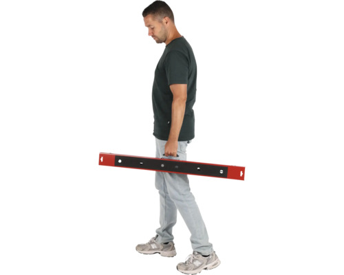 Un homme porte une règle à dresser avec une poignée