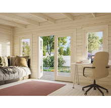 Intérieur d'une maison de jardin en bois avec lit, bureau et vue sur le jardin