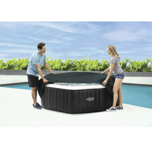 Personen legen eine schwarze Abdeckung auf einen Whirlpool von Intex