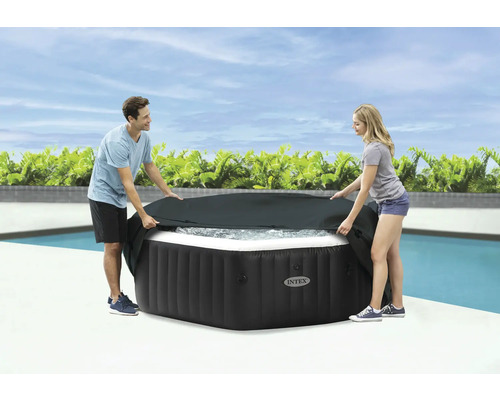 Personen legen eine schwarze Abdeckung auf einen Whirlpool von Intex