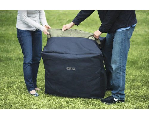 Deux personnes rangent une piscine gonflable dans un sac de la marque Intex.