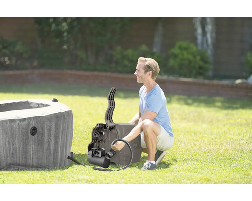 Ein Mann installiert einen aufblasbaren Whirlpool im Garten.
