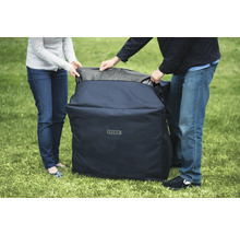 Des personnes transportent une housse de protection de la marque Intex sur une pelouse