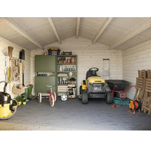 Abri de jardin organisé avec tracteur de pelouse, outils et articles de jardinage.