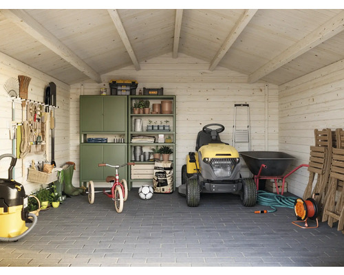 Abri de jardin organisé avec tracteur de pelouse, outils et articles de jardinage.