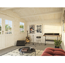 Intérieur d'un abri de jardin utilisé comme studio de musique, avec guitare, clavier et posters