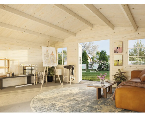 Intérieur lumineux d'une cabane de jardin avec coin atelier, canapé et vue sur le jardin