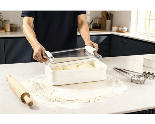 Scène dans une cuisine : un homme ouvre une boîte de conservation contenant de la pâte, entourée de farine, d’un rouleau à pâtisserie et d’emporte-pièces.
