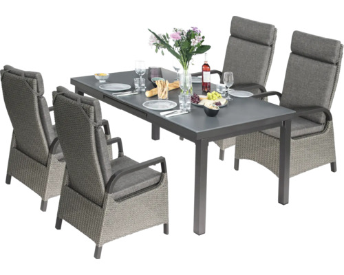 Salle à manger avec quatre chaises en rotin et table grise décorée de nourriture et de boissons.