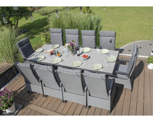 Scène de jardin avec grande table à manger et plusieurs chaises sur une terrasse