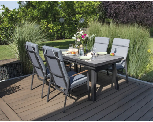 Gartenszene mit Esstisch und Stühlen auf einer Terrasse.