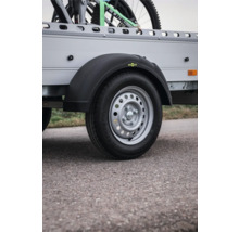 Rad eines Anhängers mit schwarzem Kunststoff-Kotflügel, Humbaur Logo und Stahlfelge.