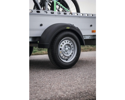 Rad eines Anhängers mit schwarzem Kunststoff-Kotflügel, Humbaur Logo und Stahlfelge.