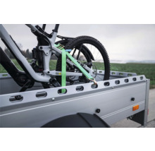 Fahrrad auf Anhänger mit einem Spanngurt gesichert.