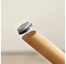 Patins en feutre avec clou sur un pied de meuble en bois