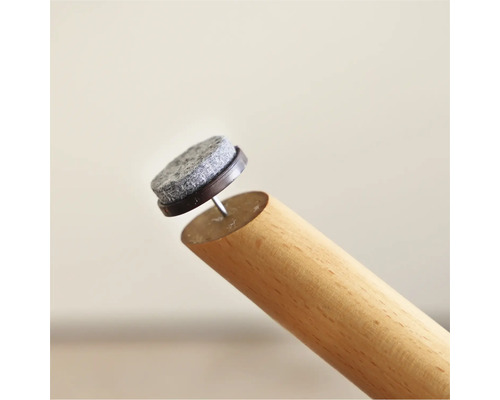 Patins en feutre avec clou sur un pied de meuble en bois