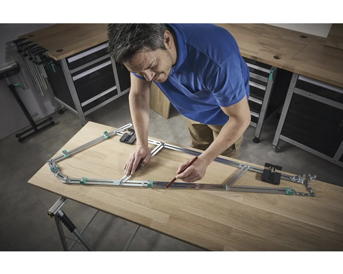 Un homme utilise un gabarit de contour pour transférer une forme sur une planche de bois.