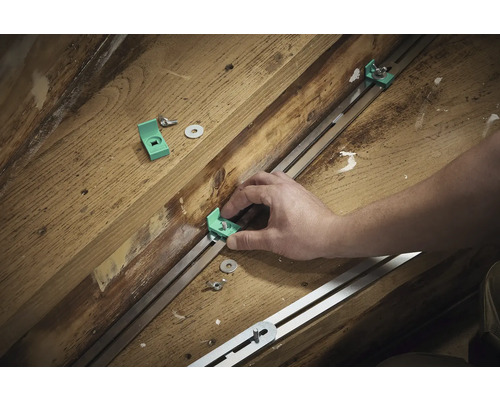 Montage d'équerres de montage avec vis et rondelles sur un rail métallique sur un support en bois