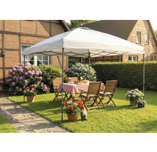 Scène de jardin avec tonnelle, table de jardin et chaises sur une pelouse devant une maison.