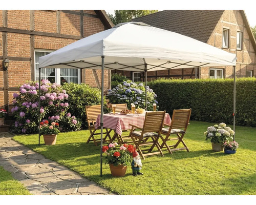 Scène de jardin avec tonnelle, table de jardin et chaises sur une pelouse devant une maison.
