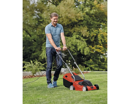Un homme tond la pelouse avec une tondeuse à gazon électrique.