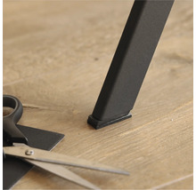 Patins pour meubles sous un pied de table et des ciseaux pour couper sur mesure