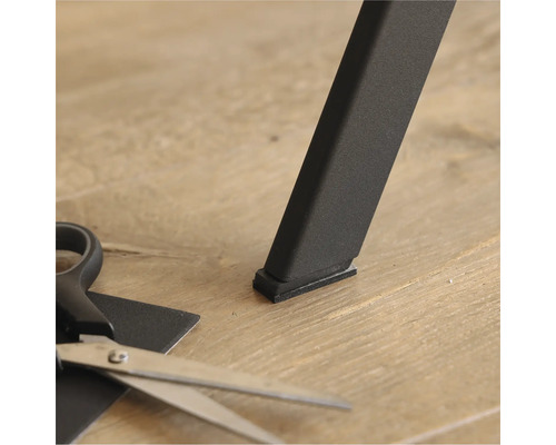 Patins pour meubles sous un pied de table et des ciseaux pour couper sur mesure