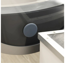 Vue détaillée d'un lave-linge avec un bouchon d'obturation rond gris