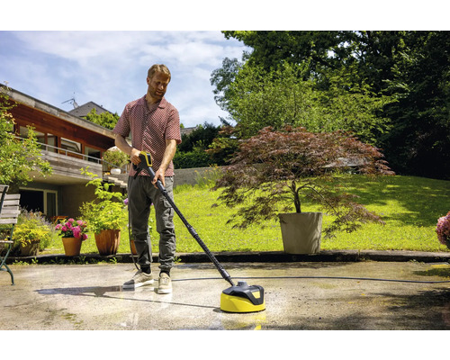 Mann reinigt Terrasse mit Hochdruckreiniger und Flächenreiniger.