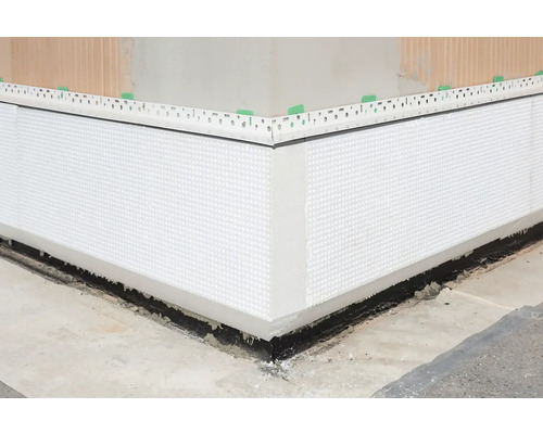 Detailansicht einer Perimeterdämmung an einer Gebäudeecke.