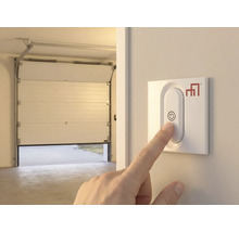 Main actionnant l'ouvre-porte de garage au mur