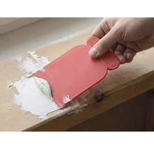 Un artisan utilise un couteau à mastic pour appliquer du produit de jointoiement.