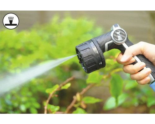 Hand hält Gartenschlauch-Spritzpistole beim Bewässern von Pflanzen