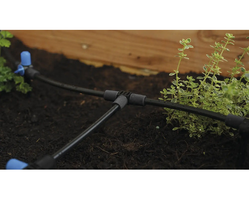 Bewässerungssystem mit Schläuchen und Verbindungsstücken im Gartenbeet