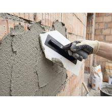 Enduire un mur de briques avec une truelle