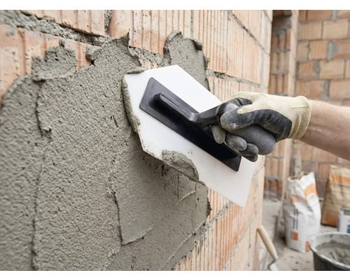 Enduire un mur de briques avec une truelle