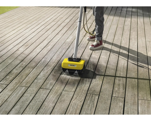 Person reinigt Holzterrasse mit Kärcher Flächenreiniger