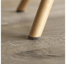 Gros plan d'un pied de chaise avec un patin en feutre pour protéger le sol.