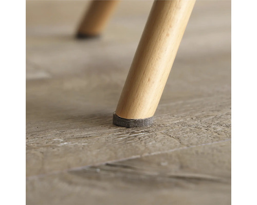 Gros plan d'un pied de chaise avec un patin en feutre pour protéger le sol.