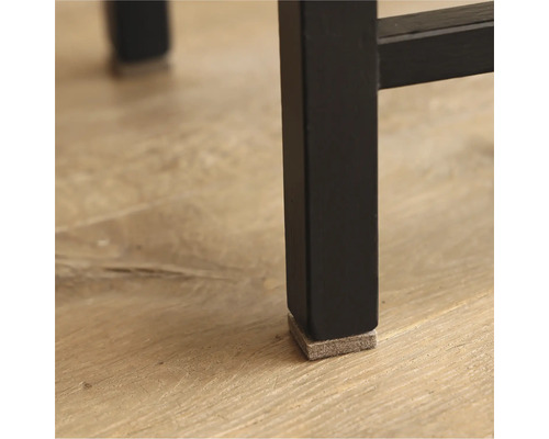Vue détaillée d'un pied de meuble noir avec un patin en feutre pour protéger le sol.