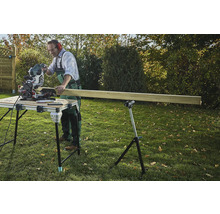 Handwerker sägt Holz mit einer Kappsäge auf einem Sägetisch im Garten.