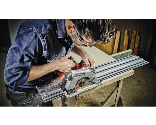Un homme scie une pièce à l'aide d'une scie circulaire plongeante Einhell.