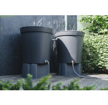 Deux réservoirs d'eau de pluie gris sur une terrasse en bois avec raccord pour tuyau d'arrosage et robinet.