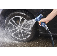 Nettoyage de voiture au jet d'eau sur le pneu et la jante