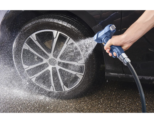 Nettoyage de voiture au jet d'eau sur le pneu et la jante