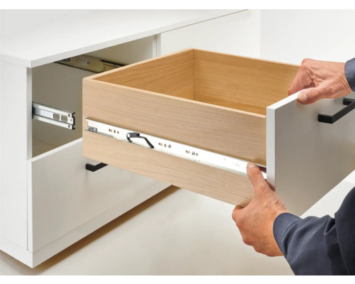 Offener Schubladenauszug an einem weißen Schrank mit Schubladenführung