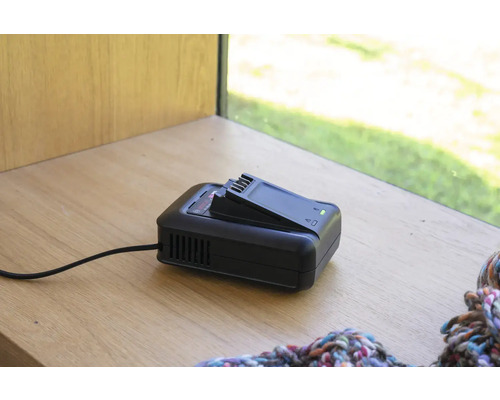 Akkuladegerät mit Akku auf einer Holzoberfläche